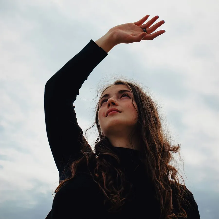 A young woman raising her hand to the sky